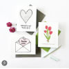 Three greeting cards with heart and tulip designs on envelopes