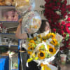 Woman holding a sunflower bouquet and two birthday balloons