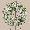 White floral wreath on a black stand