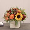 Autumn bouquet with sunflowers, orange roses, and red blooms in a wooden box