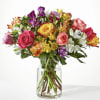 Mixed bouquet of colorful roses and alstroemeria in a clear glass vase