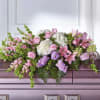 Pink and white floral casket spray with lilies, roses, and hydrangeas
