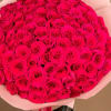 Large bouquet of bright pink roses wrapped in pale paper