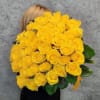 Large bouquet of yellow roses held in front of a person