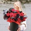 Woman holding a black box of red and black roses