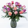 Pink and purple roses arranged in a glass vase