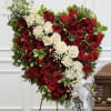 Heart-shaped arrangement of red and white roses on a stand