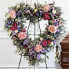 Heart-shaped floral wreath with pink roses and purple blooms