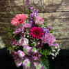 Pink and purple mixed flower arrangement with a floral ribbon bow