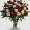 Red and white roses in a clear glass vase