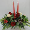 Red and white roses with evergreen foliage and two red taper candles