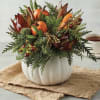 Autumn floral arrangement in a white pumpkin vase with orange pumpkins