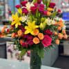 Colorful bouquet of roses and lilies in a glass vase