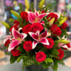 Red roses and pink lilies arranged in a glass vase