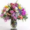 Mixed bouquet of roses and orchids in a clear glass vase