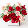 Red and blush roses arranged in a white box with a red ribbon