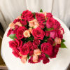 Bright arrangement of roses and spray roses in a glass cube. Simple