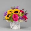 Bright mixed bouquet in a marble-pattern vase with sunflowers and pink roses