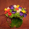 Mixed bouquet of roses, orchids, and hydrangeas in a glass vase