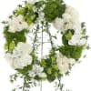 White and green floral wreath on a stand