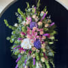 Large standing floral spray with pink lilies, roses, orchids, and purple blooms