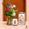 Mixed bouquet in a glass vase beside a candle and baking mix box