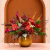 Red roses and orchids arranged in a gold vase