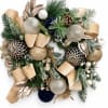 Christmas wreath with gold ribbon, ornaments, pinecones, and frosted greenery