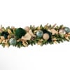 Long holiday garland with green foliage, gold leaves, and decorative ornaments