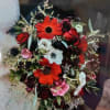 Bouquet of red, white, and pink flowers with dark foliage