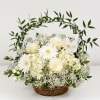 White roses and daisies in a wicker basket with a leafy arch