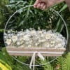 White floral arrangement in a round metal hoop with a ribbon-tied burlap wrap