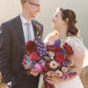 Bride and groom holding a colorful wedding bouquet and boutonniere