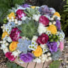 Round bouquet with pink and yellow roses, succulents, and small white daisies