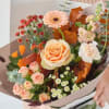Bouquet of peach and pink flowers wrapped in paper