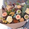 Bouquet of cream roses, pink daisies, and mixed blooms with eucalyptus