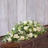 White floral casket spray with roses, calla lilies, and green accents