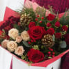 Bouquet of red and cream roses with gold pinecones in pink wrapping