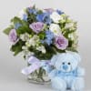 Lavender and white bouquet in a glass vase with a blue teddy bear