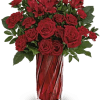 Red roses and carnations in a tall red glass vase