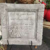 Stone memorial plaque with an angel relief and engraved verse