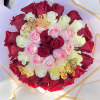 Bouquet of red, pink, and white roses wrapped in white paper with gold trim