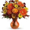 Orange and yellow mixed bouquet in an amber glass vase
