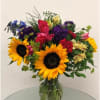Colorful mixed bouquet with sunflowers in a glass vase