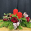 Red roses with pine branches and two red candles on a low centerpiece