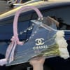 White roses in a clear handbag-shaped gift box with pink ribbon