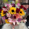 Mixed bouquet of roses, sunflowers, lilies, and chrysanthemums in a white hatbox