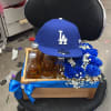 Gift box with beer bottles, blue roses, and an LA cap on a chair