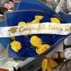 Blue and yellow rose bouquet with a graduation sash