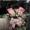 Pink rose boutonniere with baby's breath and a satin bow